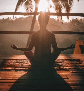 woman doing yoga meditation on brown parquet flooring